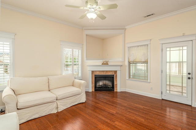 living room with ornamental molding, a fireplace, wood finished floors, and visible vents