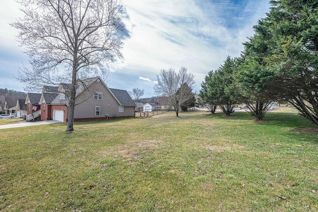 view of yard with a garage and concrete driveway