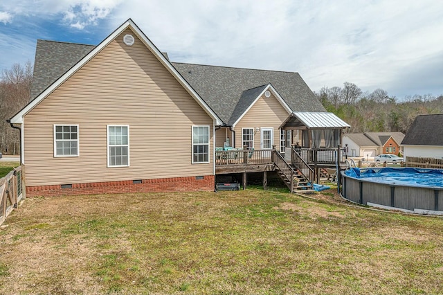 rear view of property with a shingled roof, a lawn, crawl space, a deck, and a covered pool