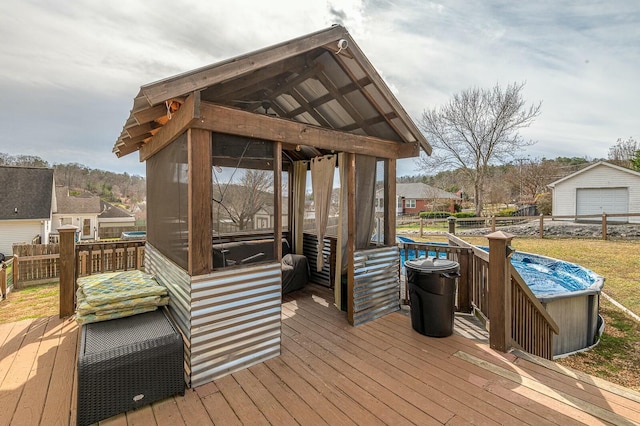 deck featuring an outbuilding, a sunroom, and fence