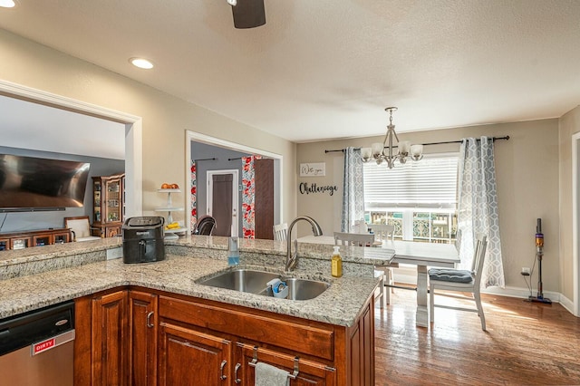 kitchen featuring dishwasher, dark wood-style floors, brown cabinets, light stone countertops, and a sink