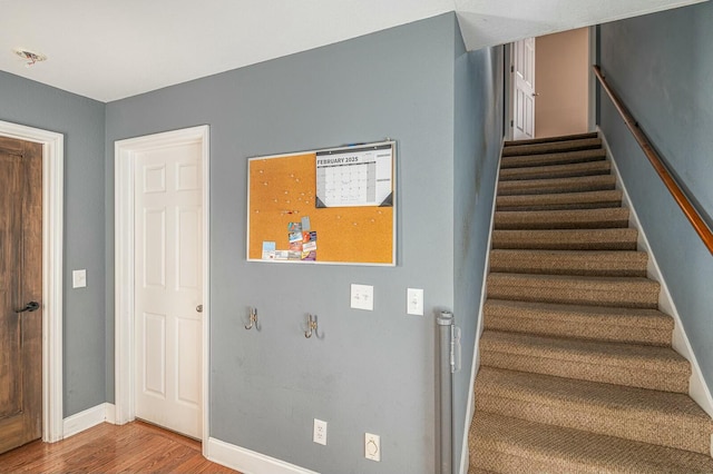 stairway with baseboards and wood finished floors