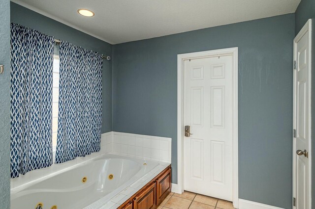 bathroom with baseboards, a tub with jets, and tile patterned floors