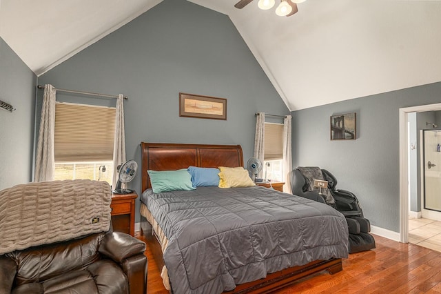 bedroom featuring high vaulted ceiling, connected bathroom, baseboards, and wood finished floors