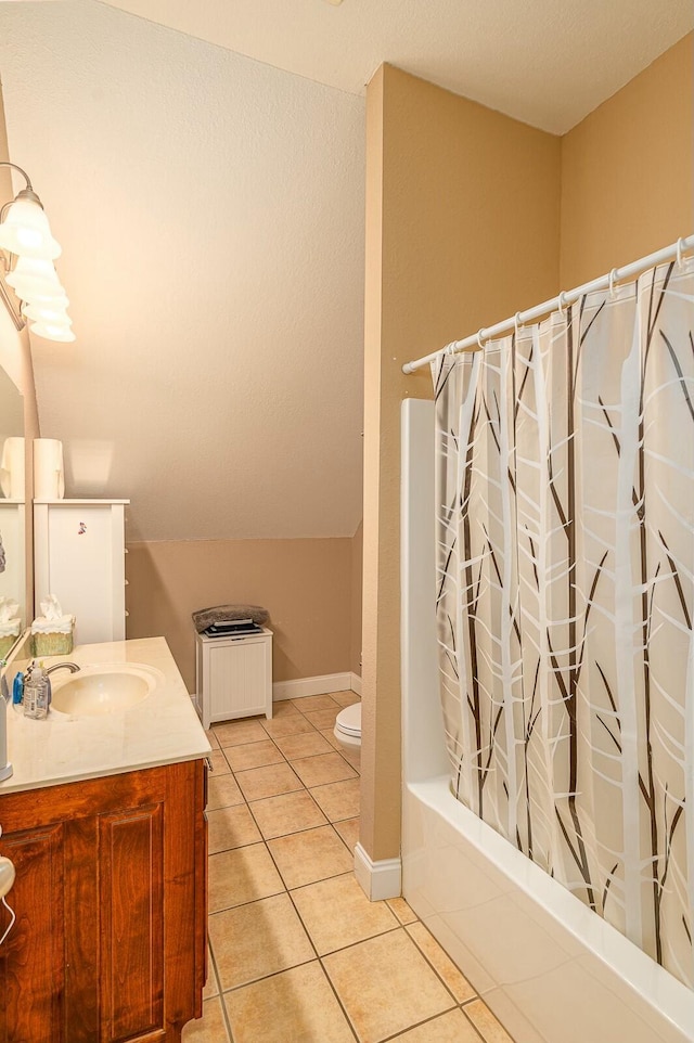 bathroom featuring tile patterned flooring, toilet, vanity, baseboards, and shower / bath combo with shower curtain