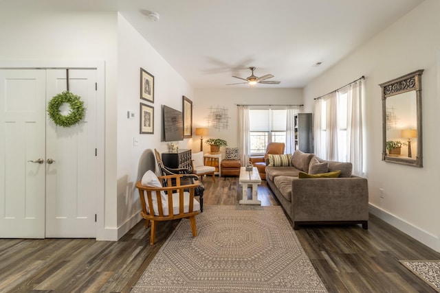 living area with dark wood-style floors, ceiling fan, and baseboards