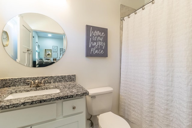 bathroom featuring curtained shower, vanity, and toilet