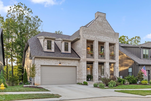 view of front of house with driveway, a shingled roof, a balcony, an attached garage, and brick siding