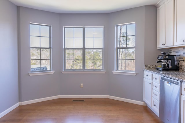 kitchen with dishwasher, wood finished floors, and baseboards