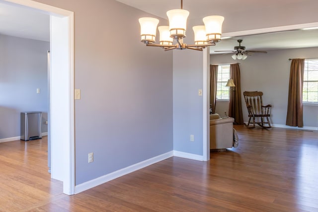 unfurnished room featuring a healthy amount of sunlight, baseboards, and wood finished floors