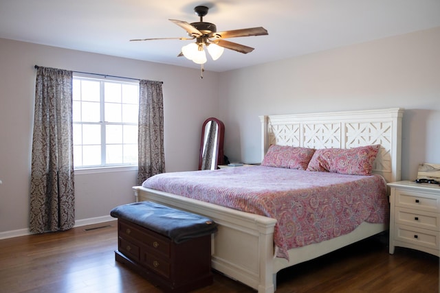 bedroom with dark wood-style floors, baseboards, visible vents, and ceiling fan