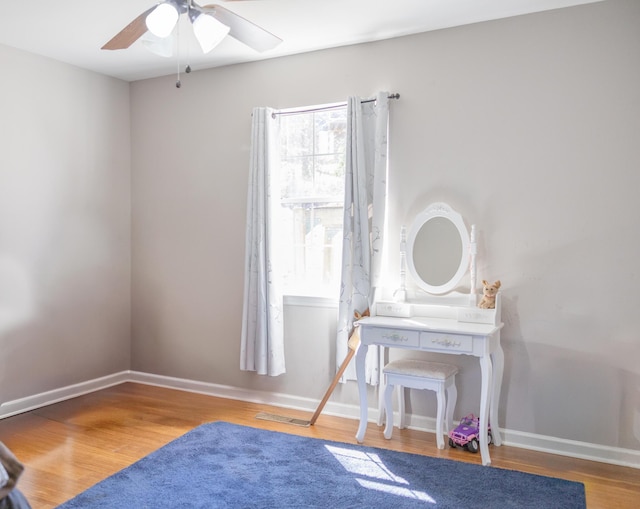 bedroom featuring a ceiling fan, visible vents, baseboards, and wood finished floors