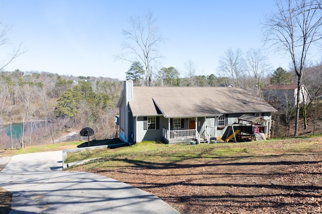 ranch-style home with covered porch, driveway, and a chimney