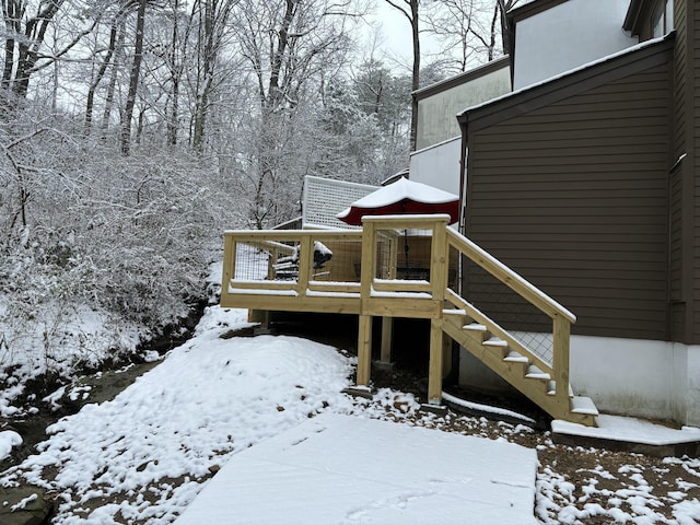 snow covered deck featuring stairway