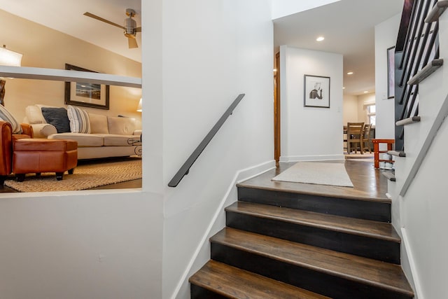 staircase featuring recessed lighting, ceiling fan, baseboards, and wood finished floors