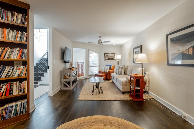 living area featuring stairway, baseboards, and wood finished floors