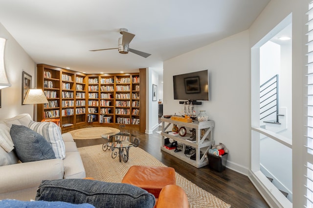 living area featuring built in features, ceiling fan, baseboards, and wood finished floors