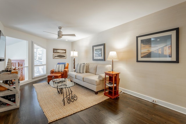 living room featuring a ceiling fan, baseboards, and wood finished floors