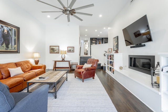 living room with recessed lighting, visible vents, wood finished floors, and a glass covered fireplace