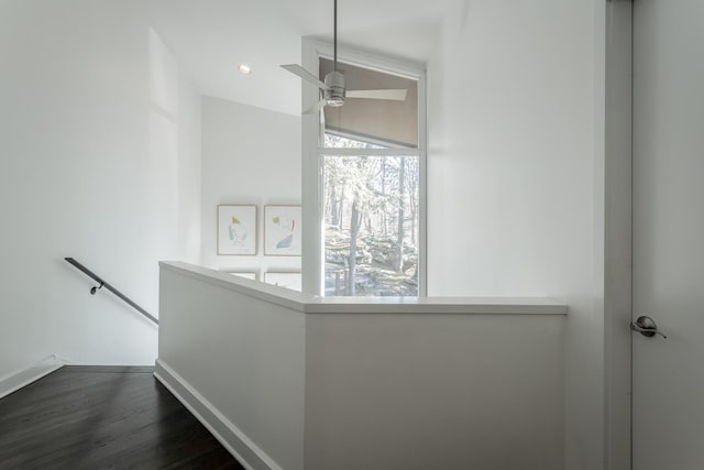 hallway featuring dark wood-type flooring and an upstairs landing