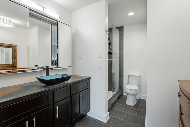 full bath with a stall shower, baseboards, toilet, tile patterned floors, and vanity