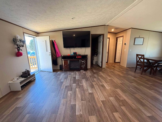 living area with a textured ceiling, ornamental molding, and wood finished floors