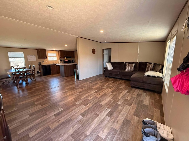 living area with dark wood-style floors, crown molding, and a textured ceiling