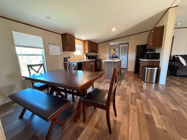 dining room featuring lofted ceiling, ornamental molding, dark wood finished floors, and recessed lighting