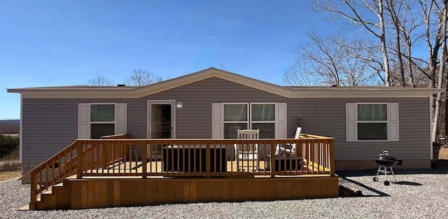 rear view of property featuring a wooden deck