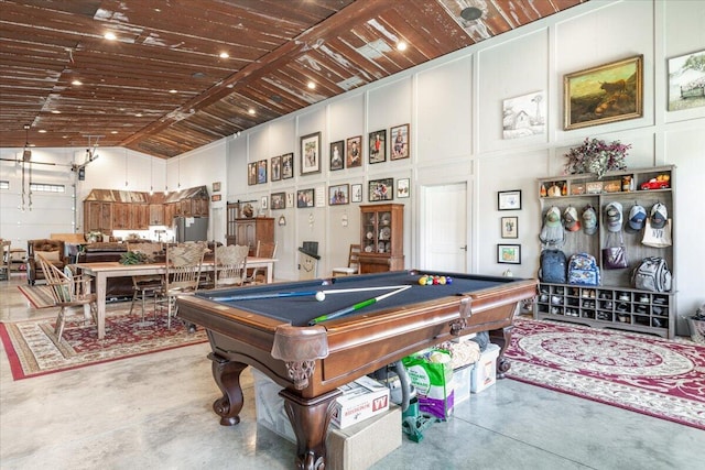 game room with concrete floors, high vaulted ceiling, a decorative wall, and pool table