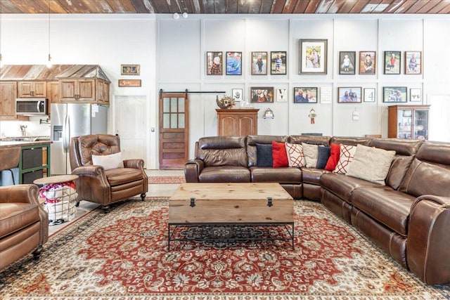 living area with wood ceiling and a barn door