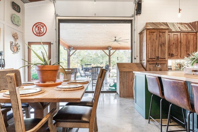 dining area with finished concrete floors and a ceiling fan