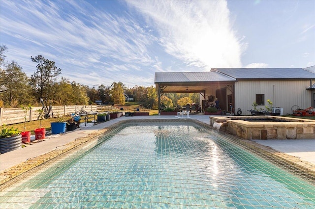 view of swimming pool featuring a patio area, fence, and a pool with connected hot tub