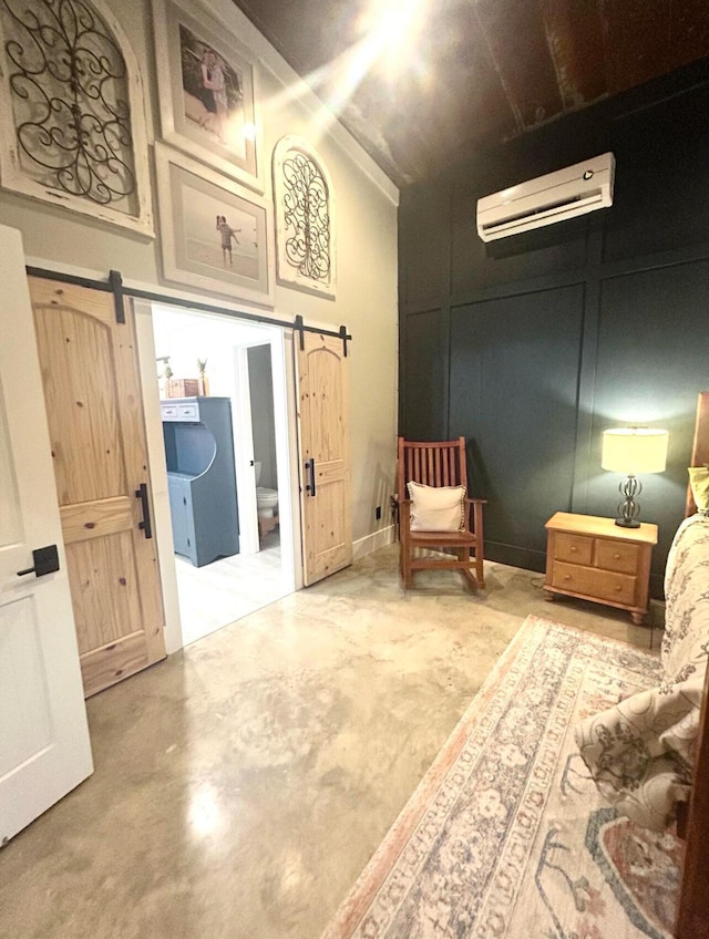 living area with a towering ceiling, a barn door, concrete floors, and an AC wall unit