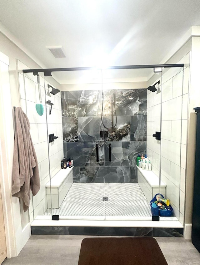 full bathroom featuring a stall shower, visible vents, and tile walls