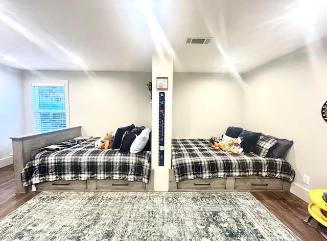 bedroom featuring baseboards, visible vents, and wood finished floors