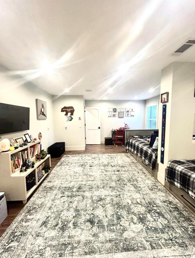 living area with visible vents, baseboards, and wood finished floors