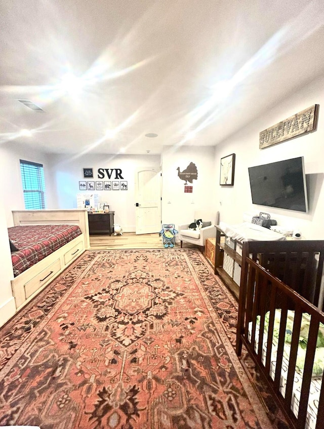 bedroom featuring visible vents and wood finished floors