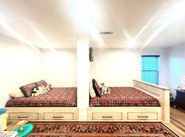 bedroom featuring visible vents and wood finished floors