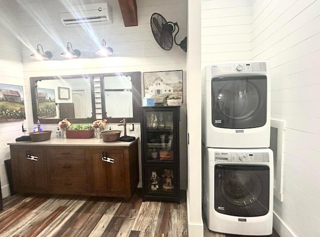 washroom with stacked washer and dryer, laundry area, wooden walls, dark wood-style floors, and a wall mounted air conditioner