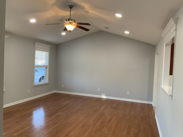 empty room featuring vaulted ceiling, ceiling fan, dark wood-type flooring, and baseboards