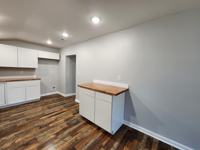 kitchen featuring dark wood-type flooring, white cabinetry, wood counters, and baseboards