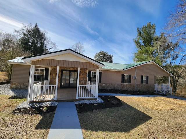 view of front of property with stone siding, metal roof, and a porch