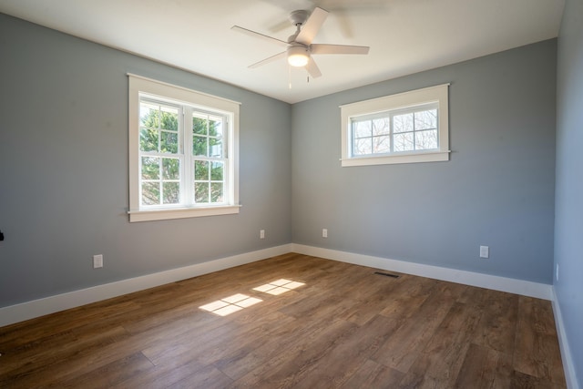 unfurnished room featuring a ceiling fan, wood finished floors, visible vents, and baseboards