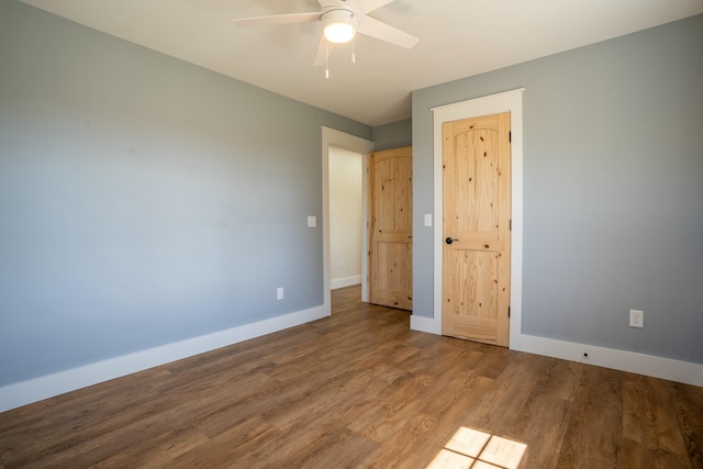 unfurnished bedroom featuring wood finished floors, a ceiling fan, and baseboards