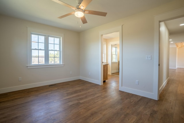 unfurnished room with visible vents, baseboards, ceiling fan, and dark wood-type flooring