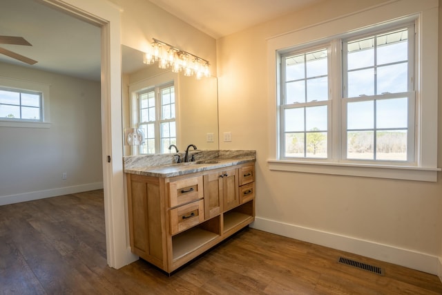 bathroom with visible vents, baseboards, and wood finished floors