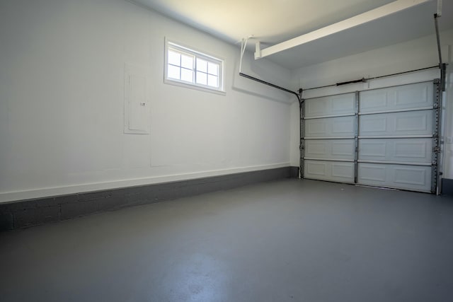 garage featuring electric panel and baseboards