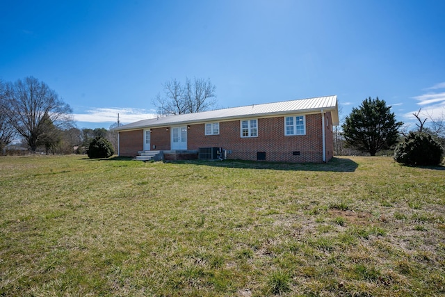 ranch-style house with metal roof, central AC, brick siding, crawl space, and a front lawn