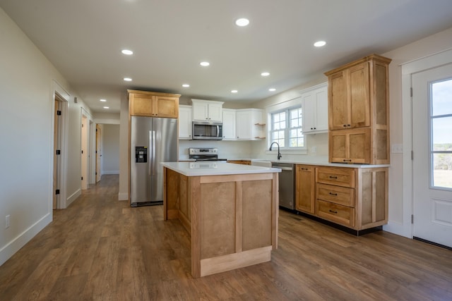 kitchen featuring dark wood finished floors, stainless steel appliances, recessed lighting, light countertops, and a kitchen island